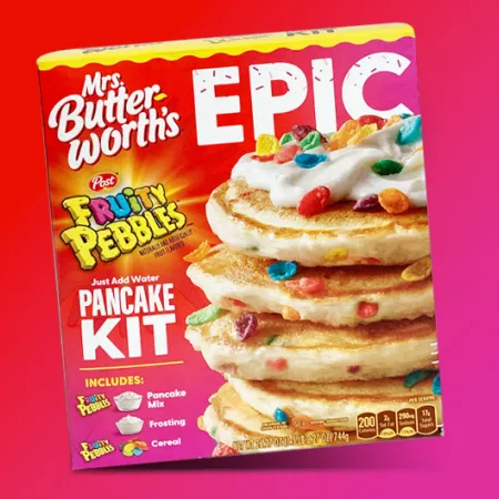 box of Epic Fruity Pebble pancake mix on red and pink background