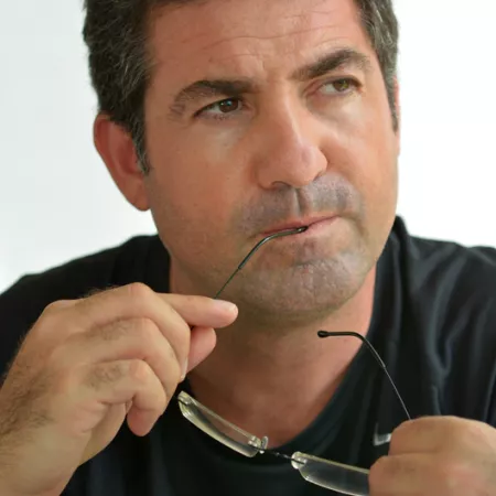 Man bighting glasses arm and thinking