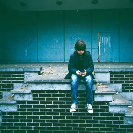 A middle school aged boy watching a video on his phone