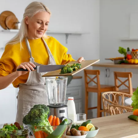 woman blending and chopping vegetables