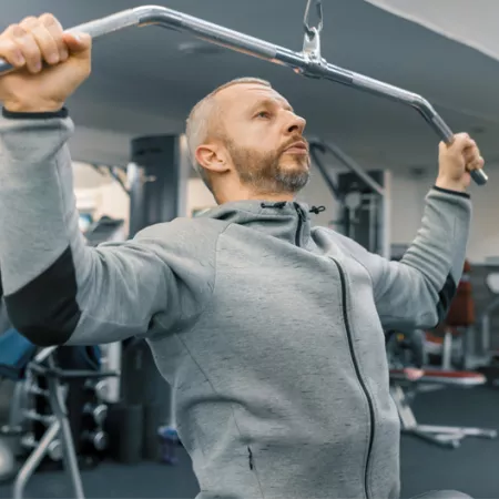 man doing pull ups in a gym