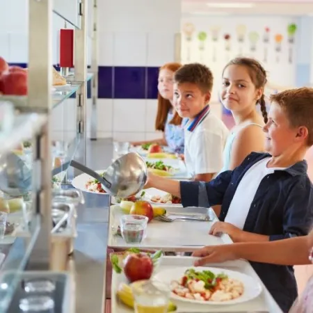 Children wait in line for a healthy school meal. In California, synthetic food dyes could soon be banned from foods sold in schools