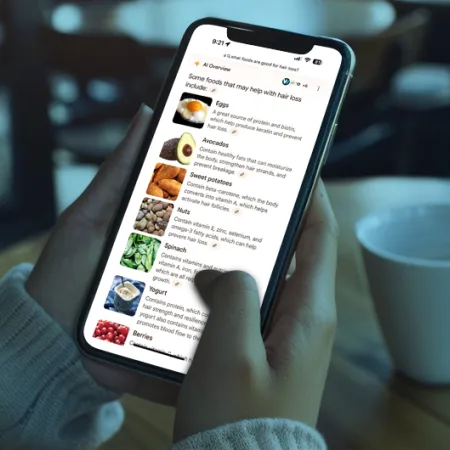 person scrolling on a smart phone in a coffee shop