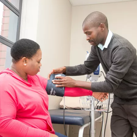 A man taking a woman's blood pressure. 