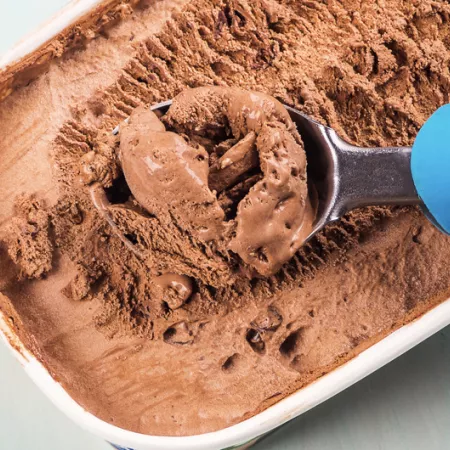 ice cream scoop in a 1.5 quart tub of chocolate ice cream