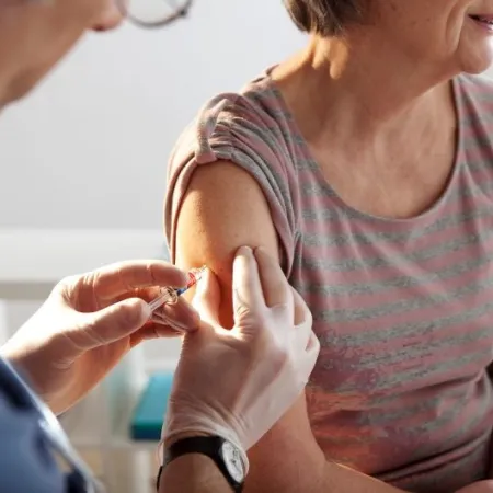 An older woman receives a vaccination shot in a doctor's office
