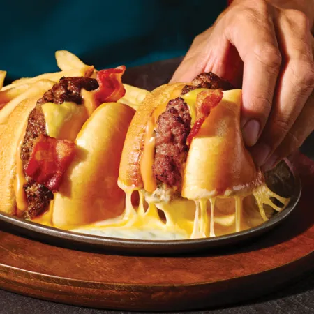 Applebee's O-M-Cheese Burger and fries with a hand picking up on half of the burger