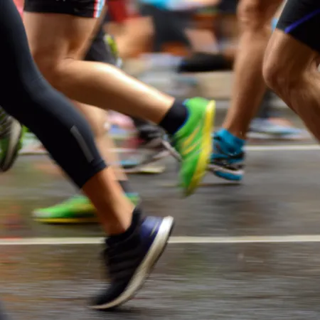 legs and feet of runners passing on a road