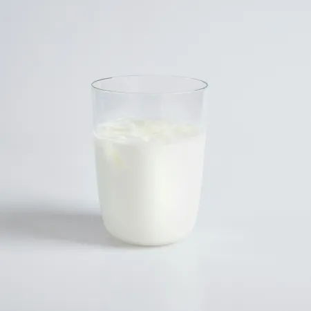 A cup of milk on a white table.