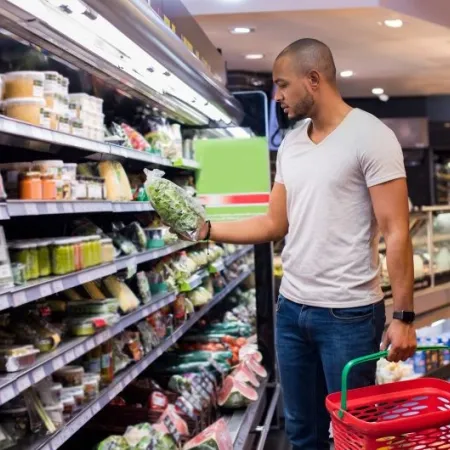 A man shops for bagged salad