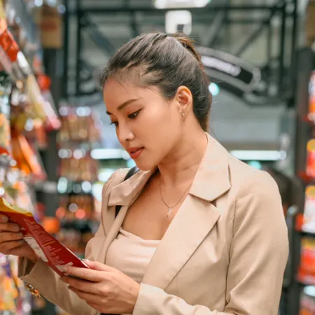 woman in grocery store looking at package of food